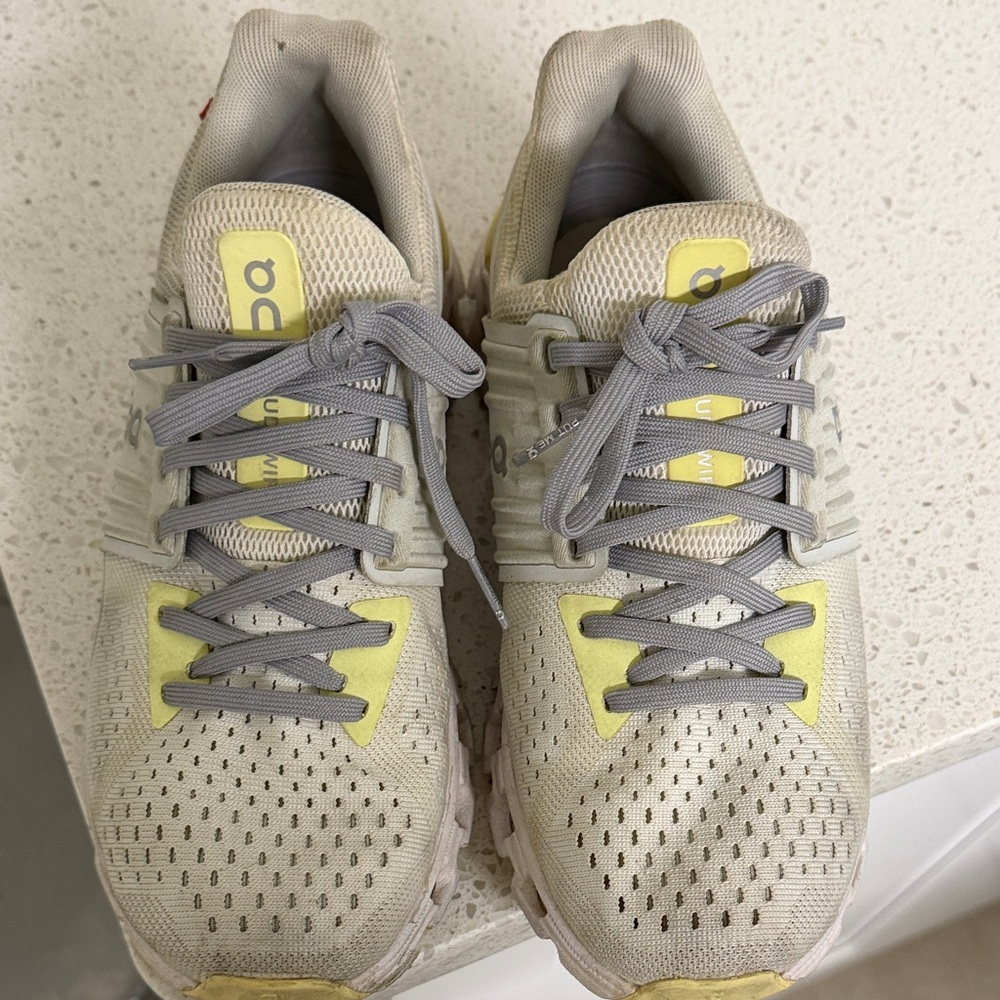 On Running Cream and Yellow Athletic Shoes